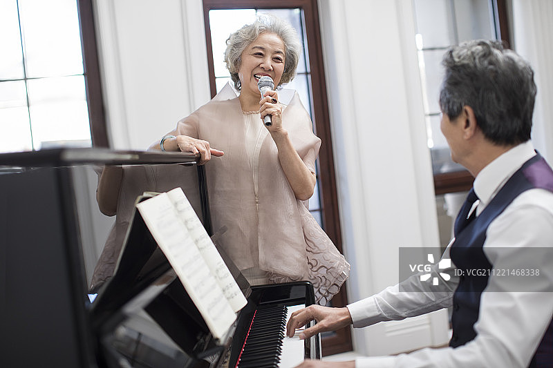 老年贵族夫妇一起唱歌弹钢琴图片素材