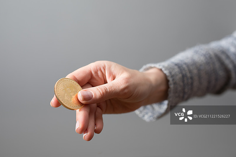 一只手拿着比特币，一种加密货币支付方式图片素材
