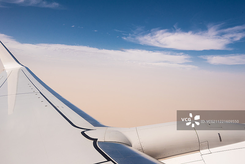 云层之上的飞机机翼与涡轮细节图片素材