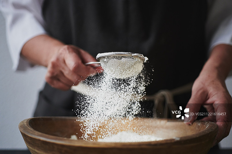 女人往碗里筛面粉图片素材