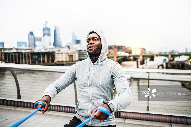 年轻的黑人运动员在伦敦用弹性橡皮筋锻炼图片素材