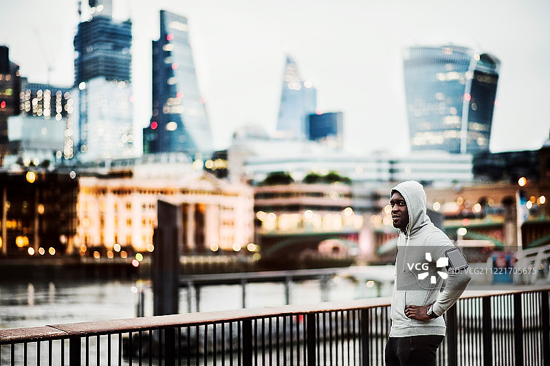 城市桥上臂带手机跑步的黑人男人图片素材