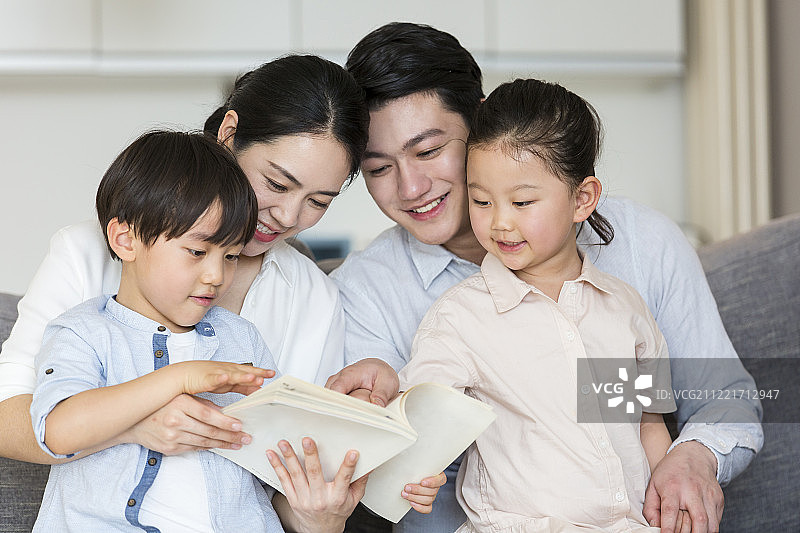 一家四口在客厅一起看书图片素材