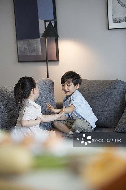 两个儿童在客厅沙发上嬉戏图片素材