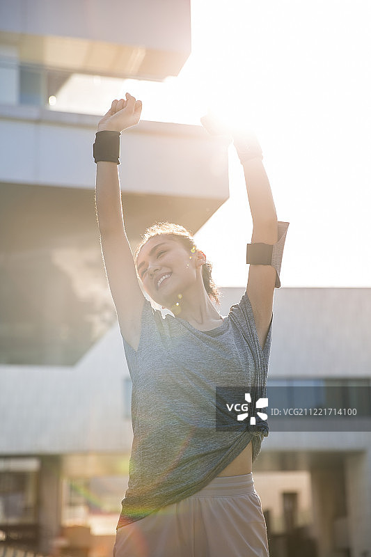 青年女子在户外伸懒腰准备运动图片素材