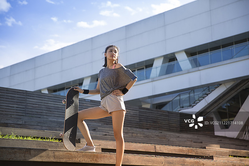 青年女子在户外拿着滑板准备运动图片素材