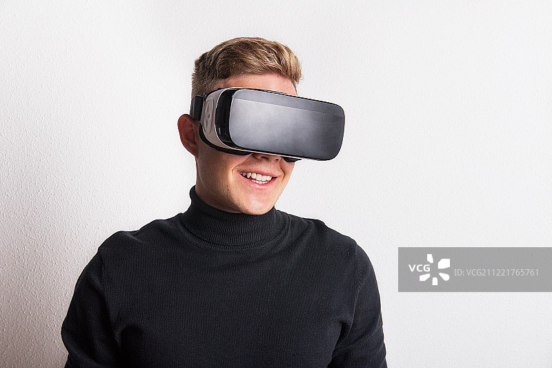 在工作室里戴着VR眼镜的年轻男人肖像图片素材