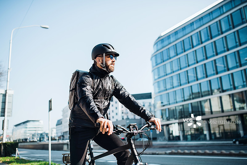 骑自行车的快递员在城市里送包裹，有文案空间图片素材