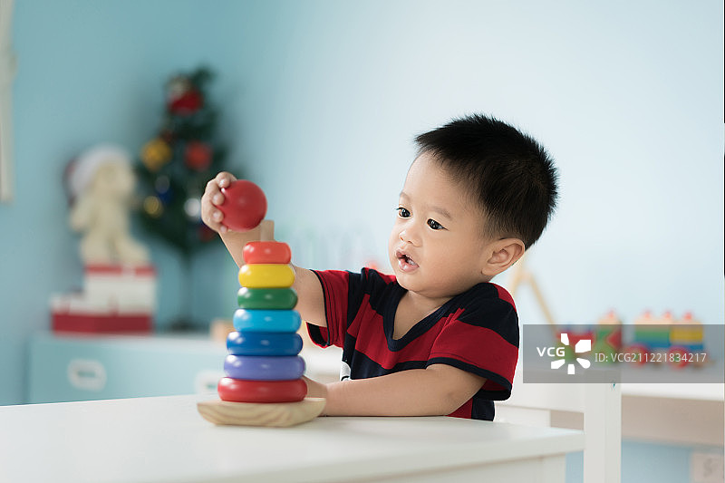 可爱的亚洲幼儿男宝宝坐在椅子上玩耍图片素材