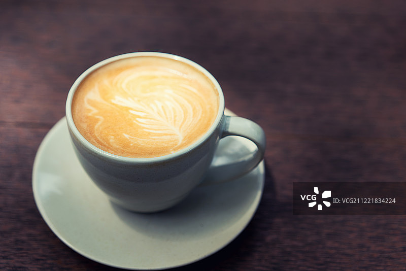 咖啡店里木桌上的热拿铁图片素材
