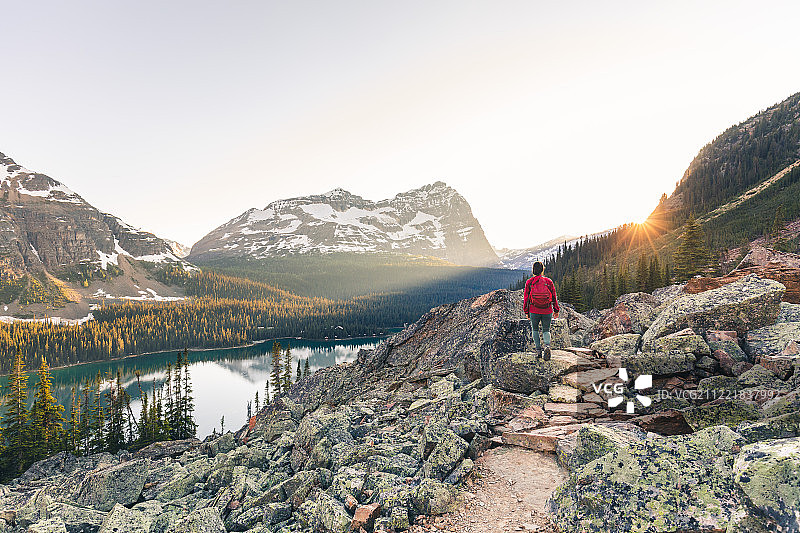 日落时分在加拿大落基山脉徒步旅行的女人图片素材