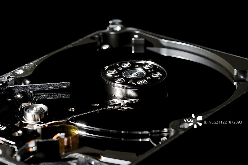 已拆卸并打开的硬盘驱动器，内部视角及反光图片素材