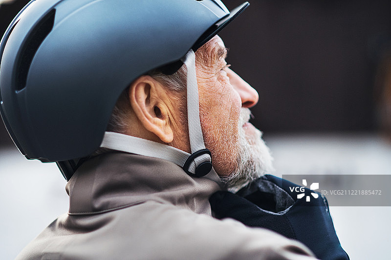 户外骑行：老年男人戴自行车头盔特写图片素材