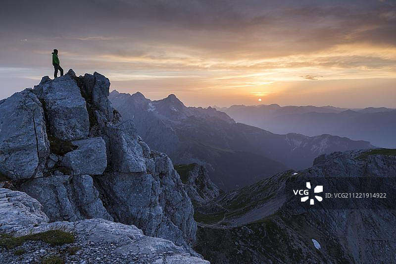 徒步者站在德赖托尔施皮策山顶，日落时分，韦特施泰因山脉，德国上巴伐利亚加米施-帕滕基兴图片素材