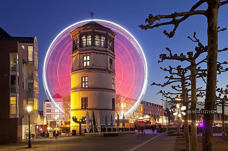 黄昏时分的莱茵河长廊，有城堡塔楼和灯火通明的摩天轮，位于德国北莱茵-威斯特法伦州杜塞尔多夫图片素材