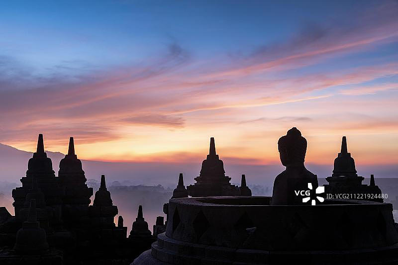 日出时分的佛像，婆罗浮屠寺庙群，印度尼西亚爪哇岛图片素材