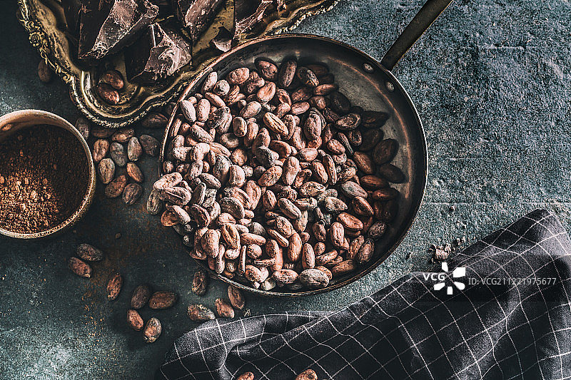 混凝土桌上的黑巧克力、可可豆和可可粉图片素材