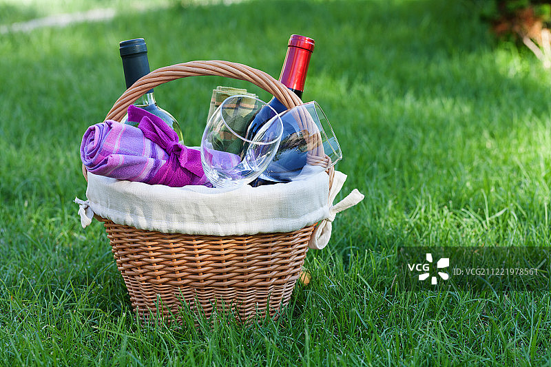 草坪上装有葡萄酒的户外野餐篮图片素材