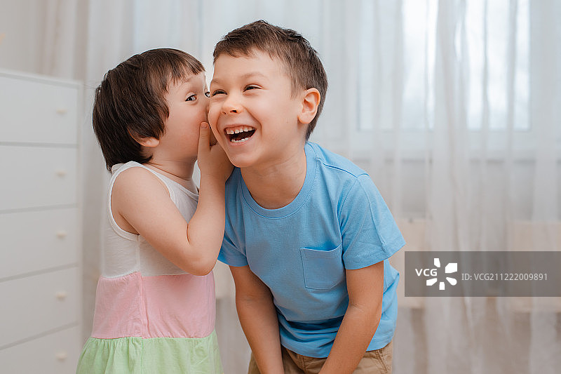 有趣的儿童，兄妹间的悄悄话和欢笑图片素材