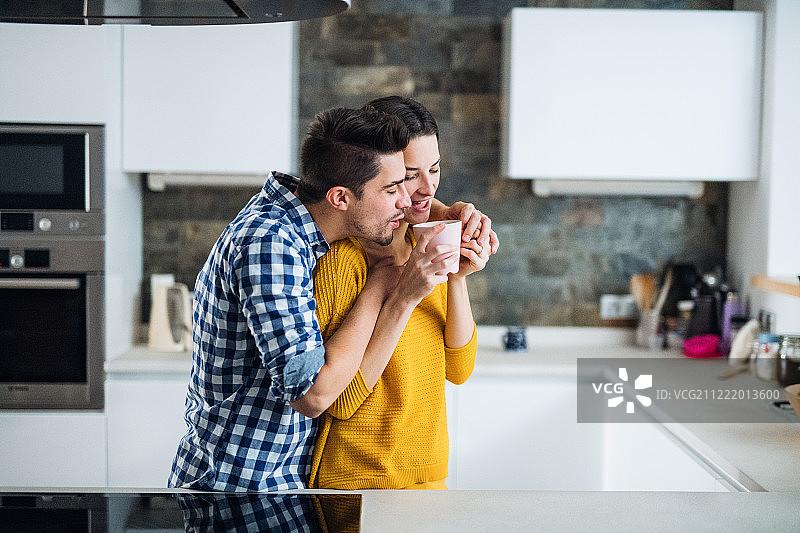 年轻情侣在家中厨房喝咖啡图片素材
