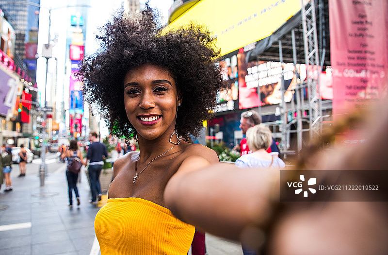 年轻漂亮女孩在曼哈顿时代广场散步图片素材