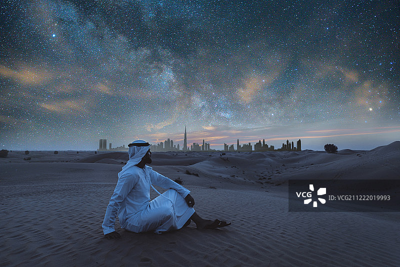 穿着坎杜拉在沙漠中行走的阿拉伯男人图片素材