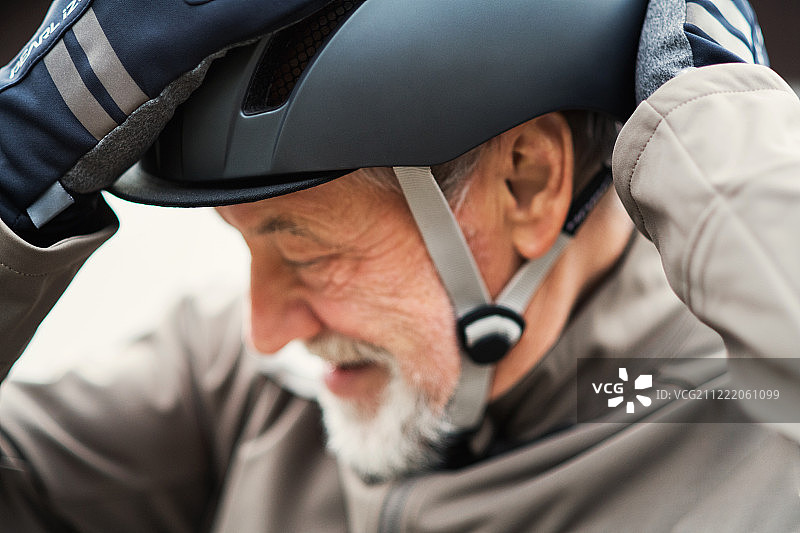 活跃的老年男人在户外小镇戴自行车头盔图片素材