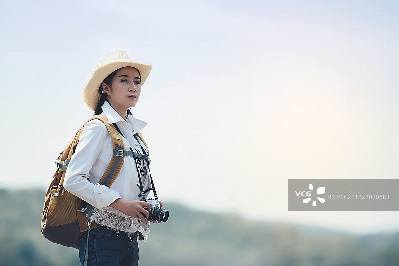 在山地景观中背着背包徒步旅行的女人图片素材