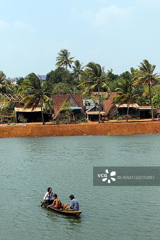 柬埔寨蒙多基里省森莫诺隆的传统房屋、棕榈树和湖上小船图片素材