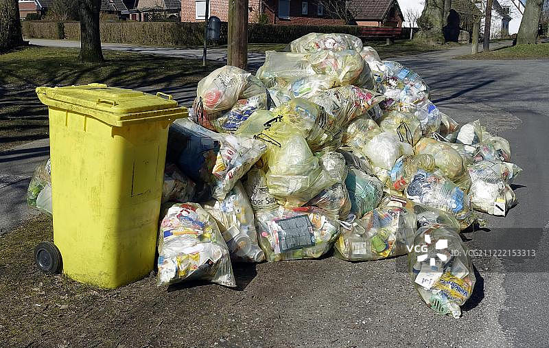 德国石勒苏益格-荷尔斯泰因州基尔-奥彭多夫的垃圾袋和回收袋堆积待取图片素材
