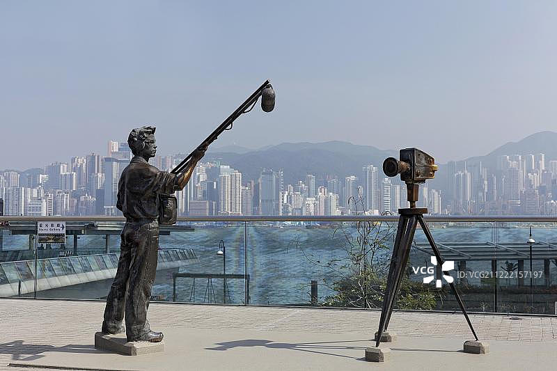 星光大道上的音响师和电影摄影机青铜雕塑，可眺望中国香港九龙尖沙咀香港岛图片素材