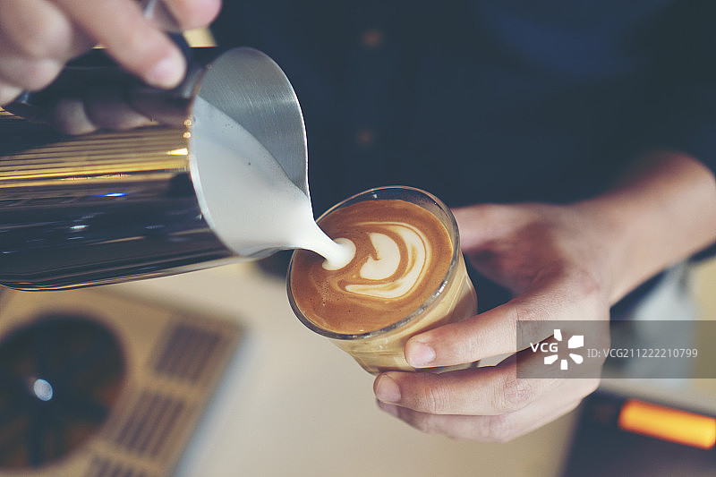 咖啡师正在制作拿铁拉花图片素材