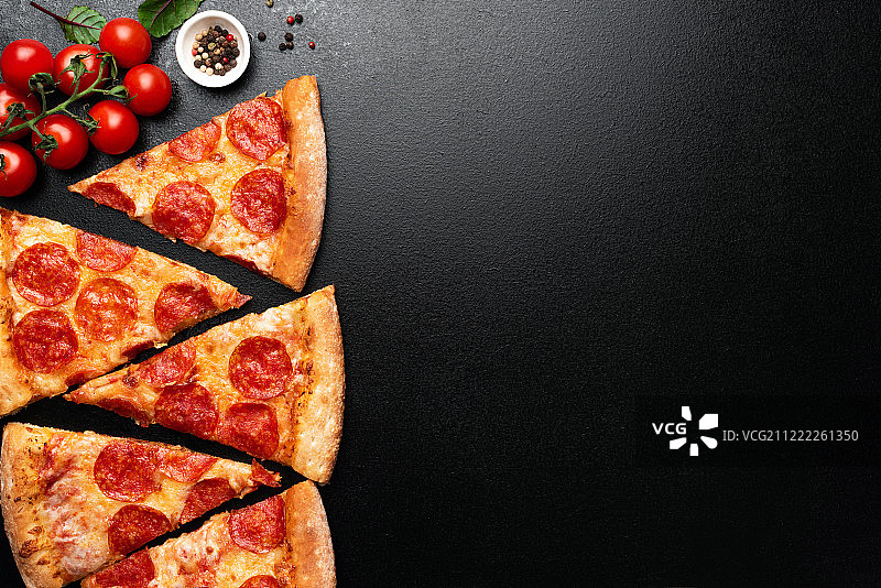 黑底上的意大利辣香肠披萨切片图片素材