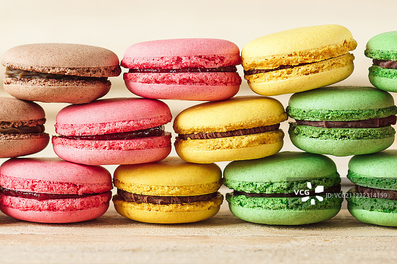 木板上的绿、粉、黄、棕色法式马卡龙图片素材