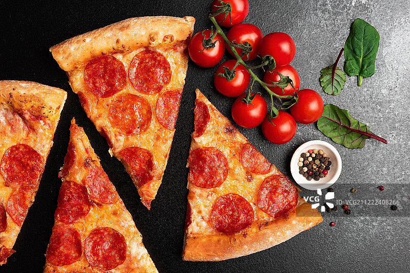 黑色背景上的意大利辣香肠披萨切片俯视图图片素材