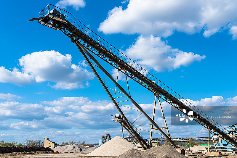 蓝色天空下砾石堆上的传送带图片素材