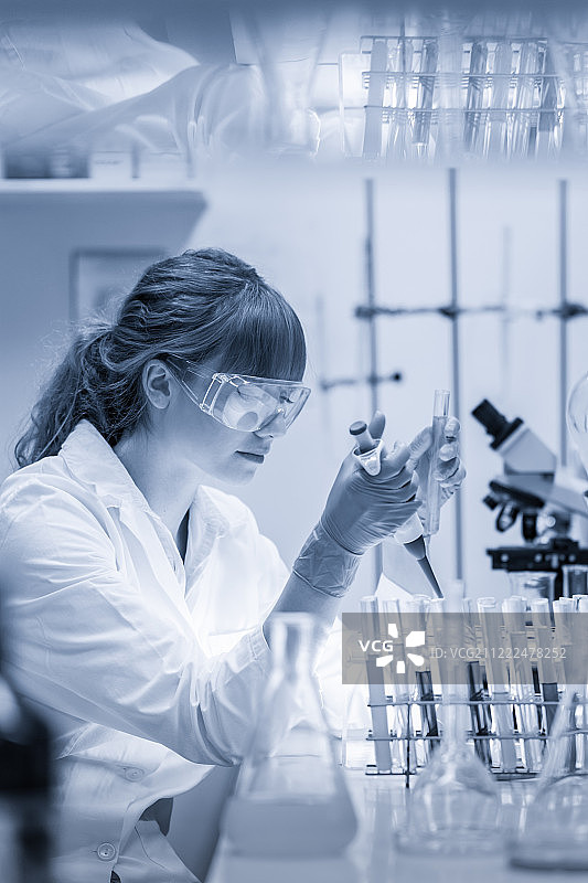 在生命科学实验室进行移液的年轻科学家图片素材