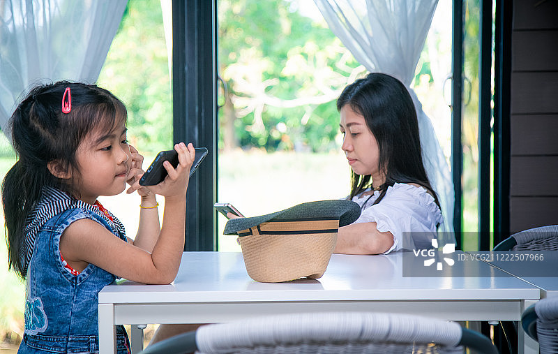 亚洲家庭使用手机的家庭活动图片素材