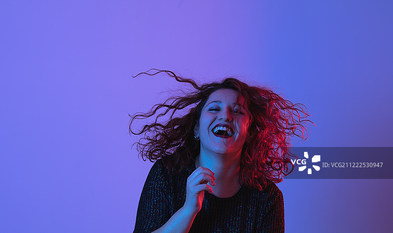 女孩在聚会上跳舞，彩色灯光，工作室拍摄，留白图片素材