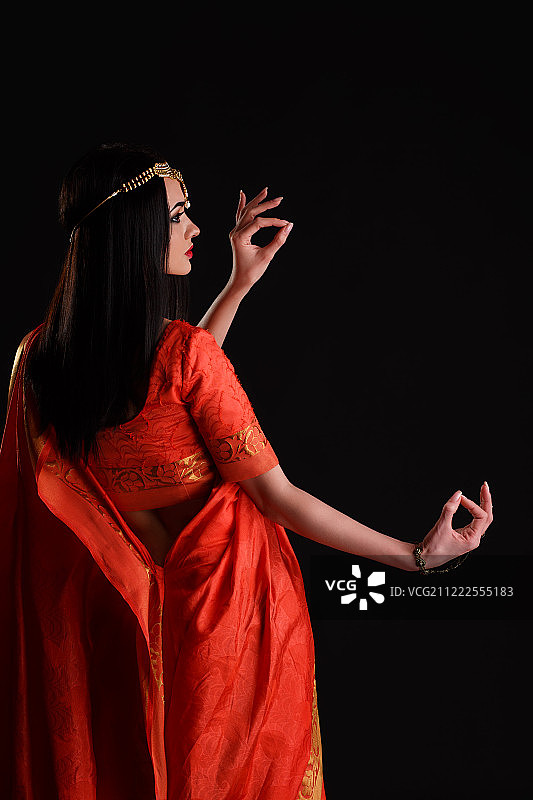 穿着纱丽在工作室微笑跳舞的印度美女图片素材