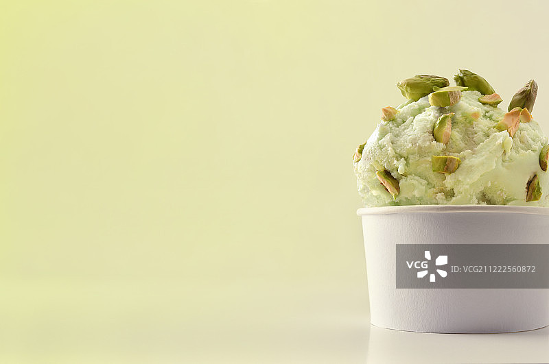 桌子上孤立的开心果冰淇淋杯特写图片素材