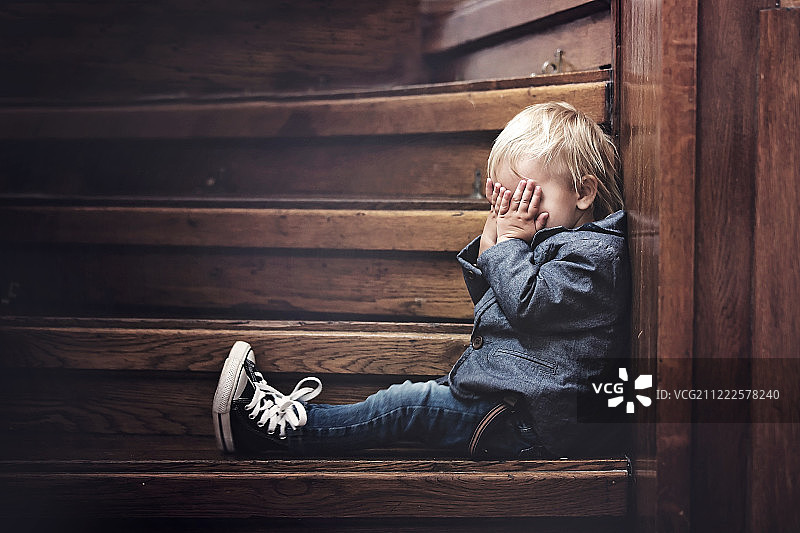 坐在大房子楼梯上的悲伤儿童图片素材