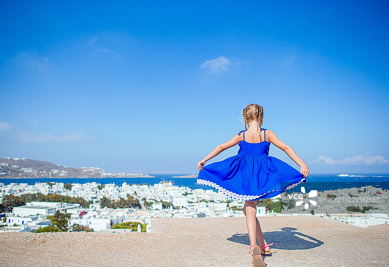 在典型希腊传统村庄老街上的可爱小女孩图片素材
