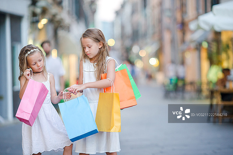 拿着购物袋的漂亮微笑的小女孩图片素材