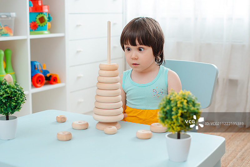小女孩收集木制未上漆金字塔安全天然儿童玩具图片素材