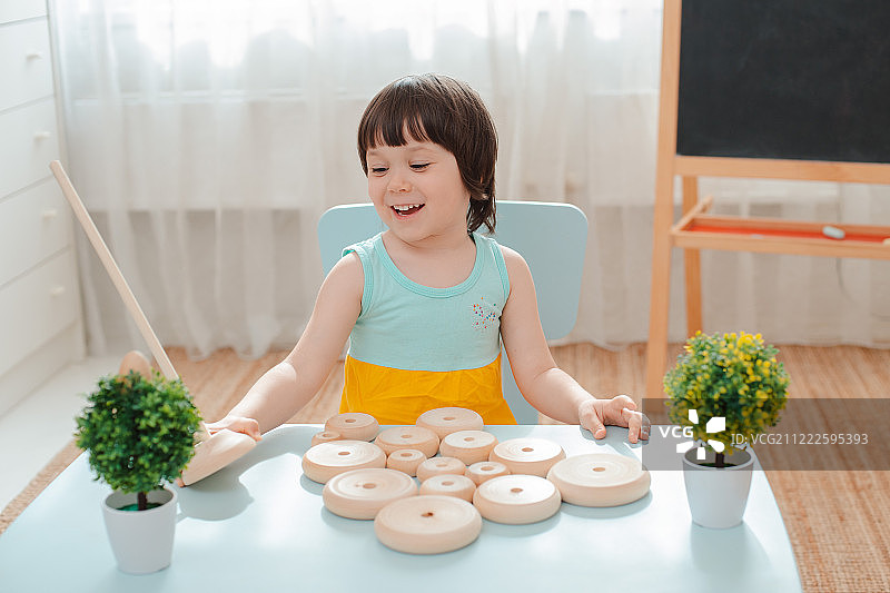 小女孩收集木制未上漆金字塔安全天然儿童玩具图片素材