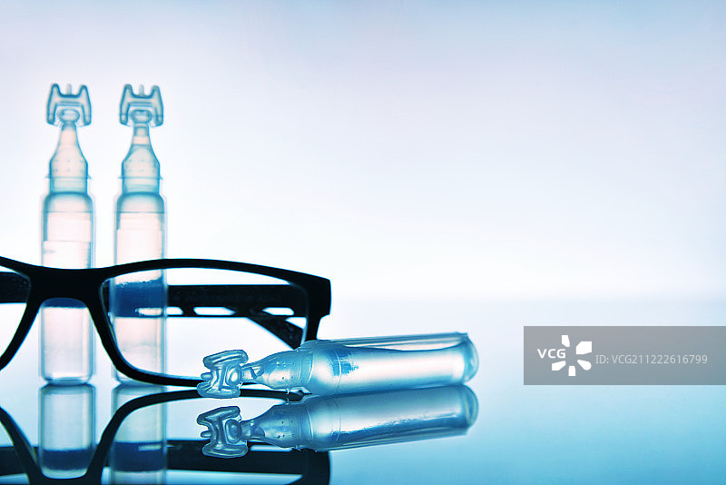 滴眼液、眼镜与蓝色背景图片素材