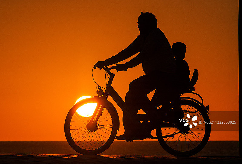 父子在日落时骑行图片素材