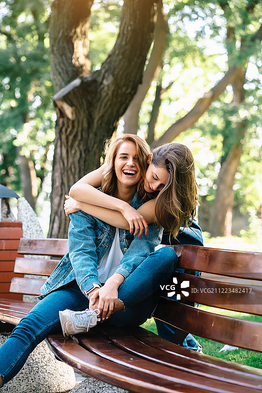 在长椅上休息的两名美丽的年轻女子图片素材