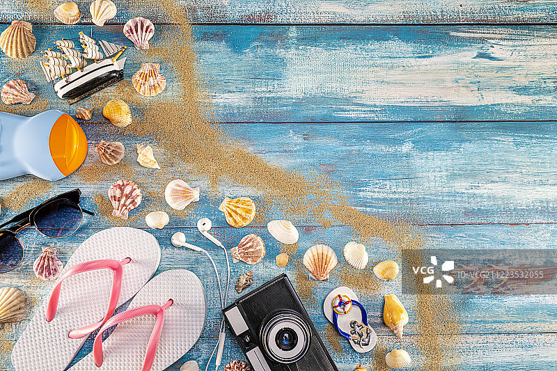 海滩配件：复古相机、太阳镜、人字拖与大海图片素材
